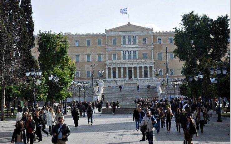 Menschen in Athen laufen auf Platz vor Parlament