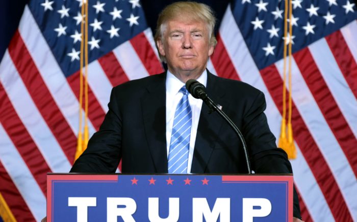 Donald Trump vor zwei US-Fahnen