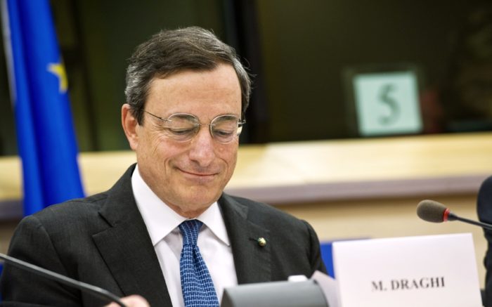 EZB-Präsident Mario Draghi an einem Tischmit Namensschild und Mikrofon
