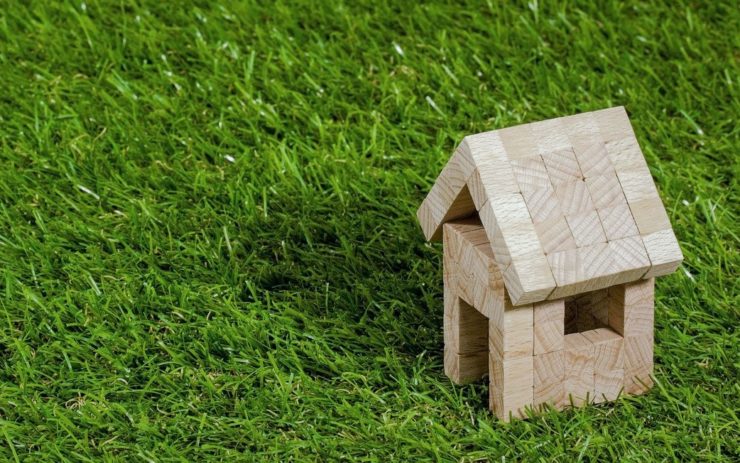 Gute Investition: Ein Haus aus Bauklötzen steht auf grünem Rasen.