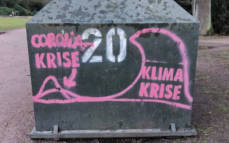 Graffiti: Eine große Welle mit der Aufschrift "Klima-Krise" überrollt eine kleinere Welle mit der Aufschrift Corona-Krise