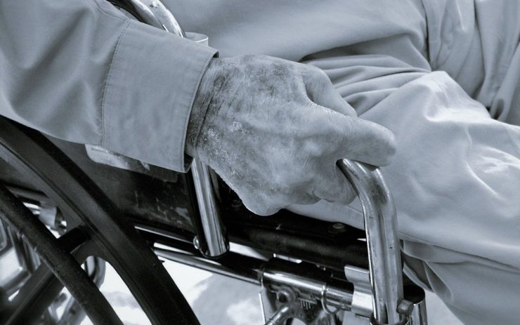 Ein Mensch sitzt im Rollstuhl in der Pflege