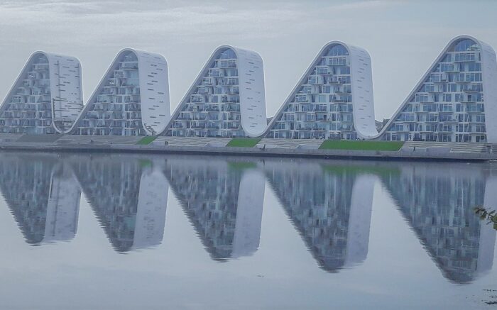 Wohnen am Wasser: Architektonisch interessante Gebäude in Wellenform stehen am Wasser