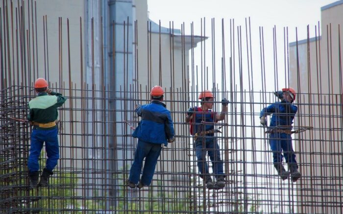 Beschäftigte der Baubranche hängen in einem Stahlgitter