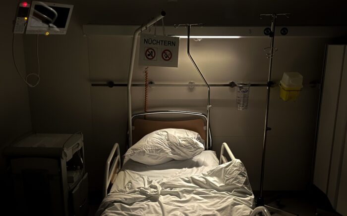 Ein spärlich beleuchtetes Krankenhausbett mit unordentlichen Laken
