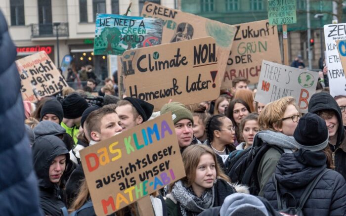 Auf einer Friedas for Future Demonstration halten Jugendliche Schilder hoch. Auf ihnen steht "Das Klima ist wichtiger als unser Mathe-Abi" und "Climate Now, Homework later!"