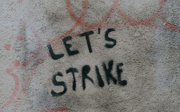 Auf einer grauen Wand wurde auf Englisch ein Aufruf zum Streik gesprüht