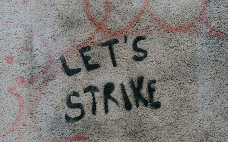 Auf einer grauen Wand wurde auf Englisch ein Aufruf zum Streik gesprüht