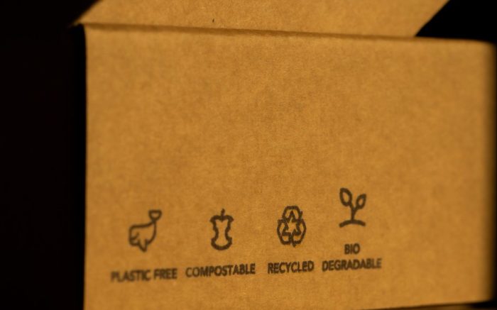 auf einer braunen Verpackungsbox steht "Plastic free", "Compostable", "Recycling" und "Bio Graded"