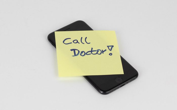 Ein App-Telofon mit draufliegendem Notizzettel auf dem steht "call a doctor!". Apps