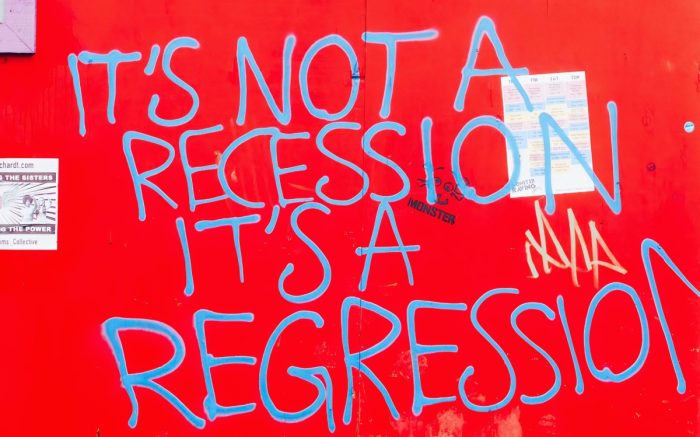 "It's not a recession it's a regression" als Graffiti auf rotem Grund